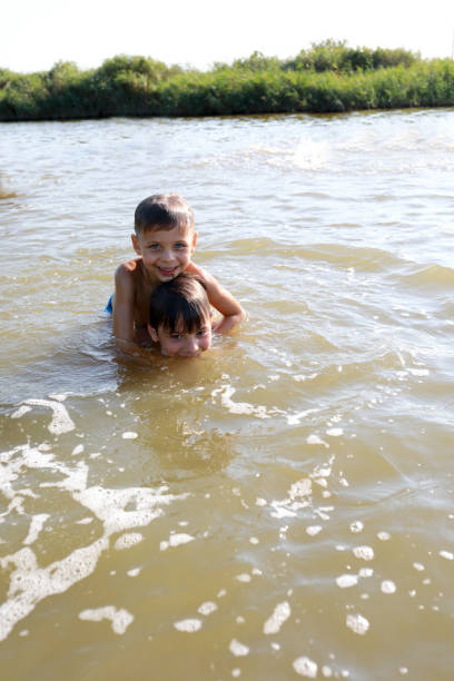 istock Two brothers swimming in lake 1270591786