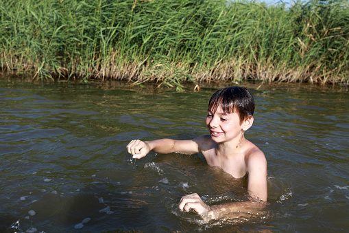 Kid swimming in lake, Krasnodar region, Russia