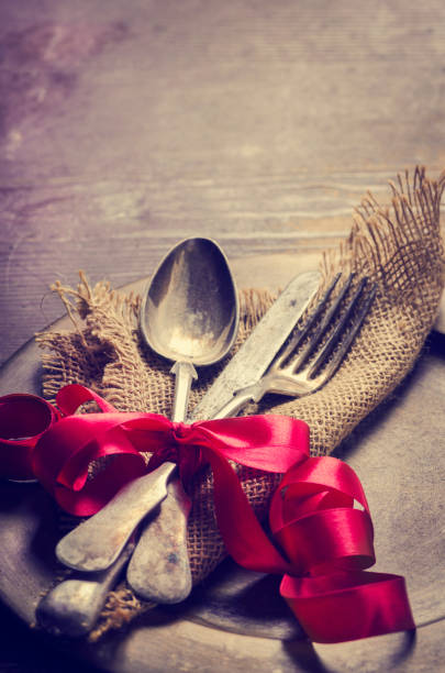 istock Vintage silverware decorated with red ribbon. Valentine's dinner setting background. 1270592392
