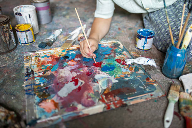 istock Young artist using a paintbrush to take paints from the palette 1270593708