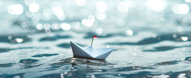 istock Paper Boat sailing on sunny sea 1270596565