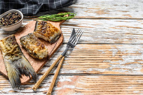 istock Grilled river fish silver carp on a cutting board. Wooden background. Top view. Copy space 1270597849