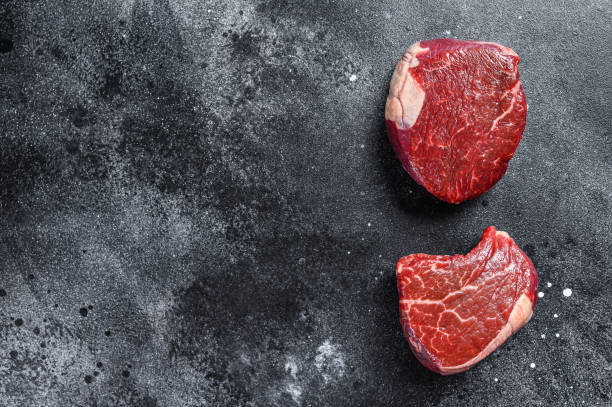 istock Raw beef meat steak Tenderloin fillet. Black background. Top view. Copy space 1270598147