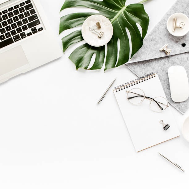 istock Home office workspace mockup with laptop, tropical leaves Monstera, clipboard, notebook and accessories on white background. Flat lay, top view 1270598281