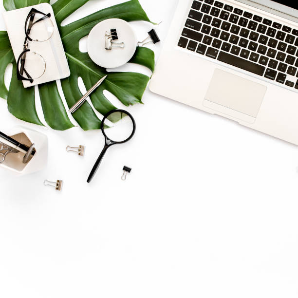 istock Home office workspace mockup with laptop, tropical leaves Monstera, clipboard, notebook and accessories on white background. Flat lay, top view 1270598524