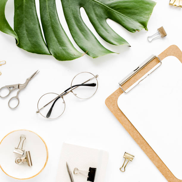 istock Home office workspace mockup with tropical leaves Monstera, clipboard, and accessories on white background. Flat lay, top view 1270599247