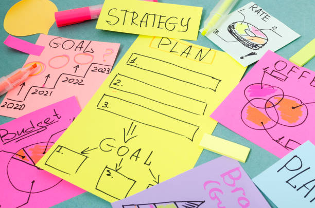 istock Closeup of colorful paper notes on the blue table.Handwritten notes for Plan, Offer, Goals, Strategy 1270602037