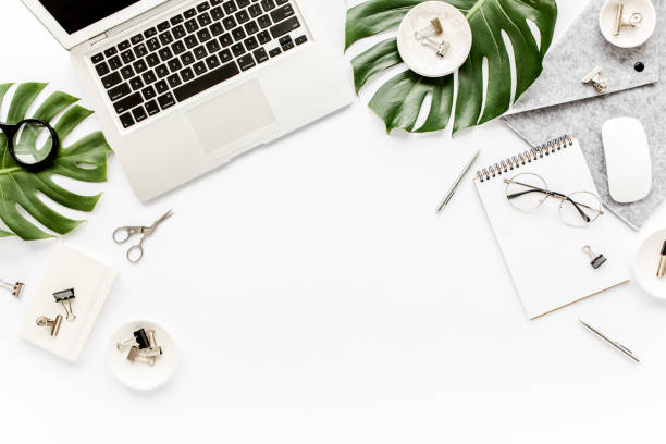 istock Home office workspace mockup with laptop, tropical leaves Monstera, clipboard, notebook and accessories on white background. Flat lay, top view 1270602527