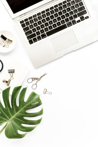 istock Home office workspace mockup with laptop, tropical leaves Monstera, clipboard, notebook and accessories on white background. Flat lay, top view 1270602758