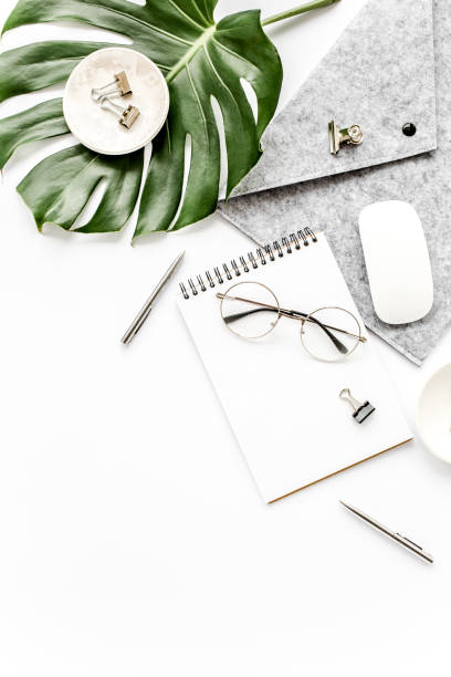 istock Home office workspace mockup with laptop, tropical leaves Monstera, clipboard, notebook and accessories on white background. Flat lay, top view 1270602942