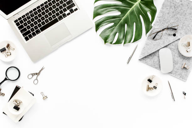 istock Home office workspace mockup with laptop, tropical leaves Monstera, clipboard, notebook and accessories on white background. Flat lay, top view 1270603730