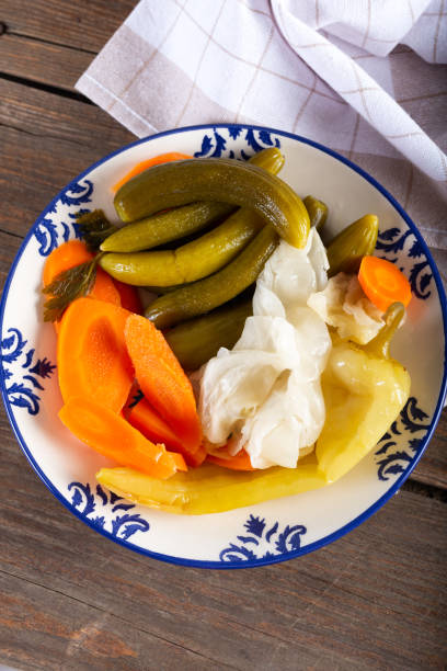 istock Assorted pickled vegetables in bowl/plate on natural wooden background. Top view. 1270604793