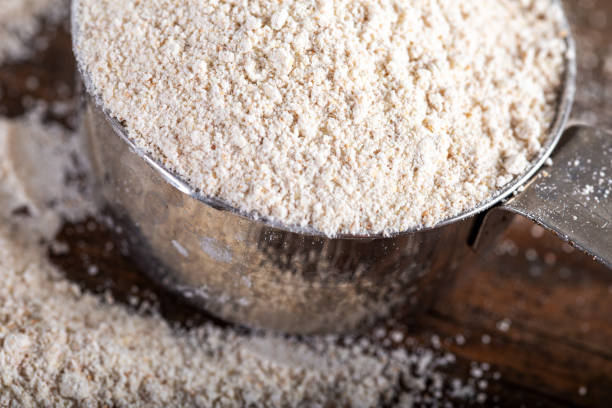 istock whole wheat flour in metal measuring cup on natural background. 1270605512