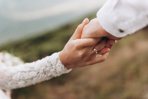 istock wedding theme, holding hands newlyweds. Groom and bride on the mountans 1270610984