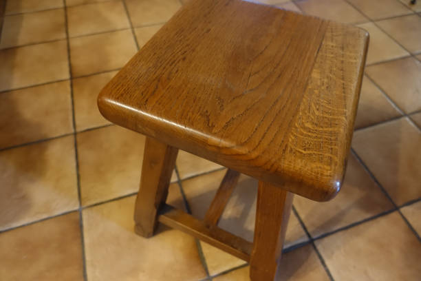 istock Solid oak wood stool on a tiled floor  Artisanal product 1270613262