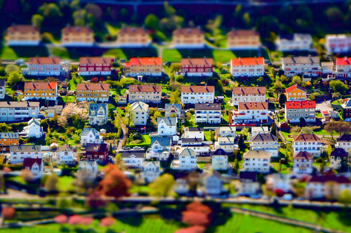 Tilt-shift creative image of an upper-class residential city suburb district with houses and gardens. Miniature effect