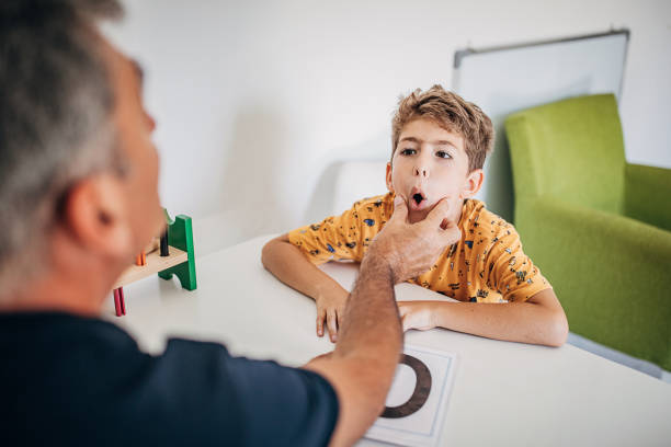 istock Male speech therapist teaches a boy to say letters properly 1270614017