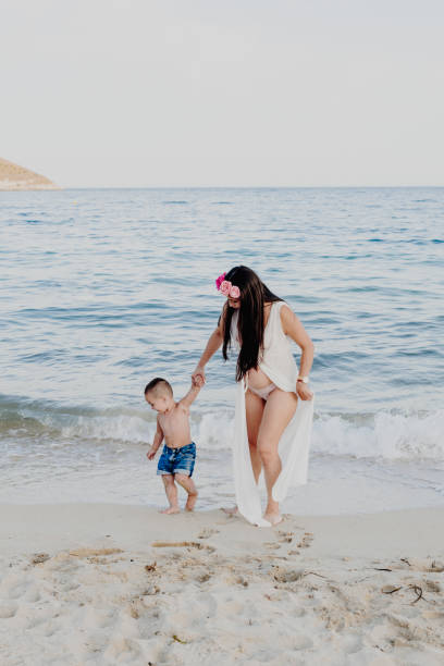 istock Pregnant mother and her son on the seashore 1270614159
