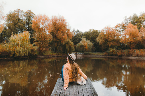 Photo of a young woman enjoying nature alone, taking out some time from her highly busy schedule to relax by the river.