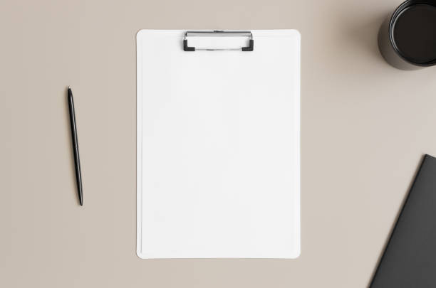 istock White clipboard  mockup with a cup of coffee and workspace accessories on a beige table. 1270614799