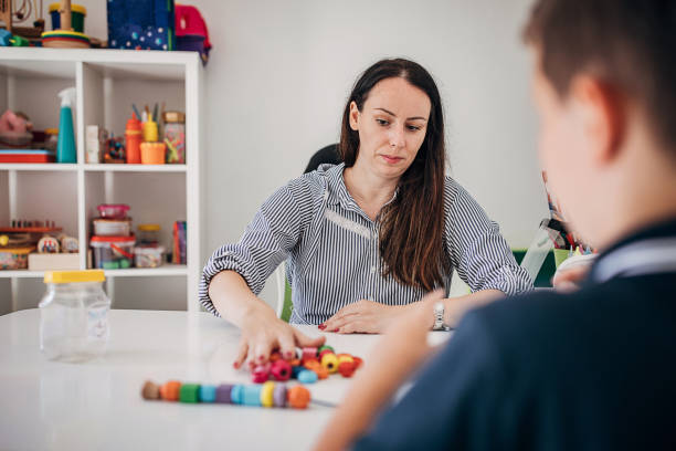 istock Preschool boy making necklace with his therapist 1270615714