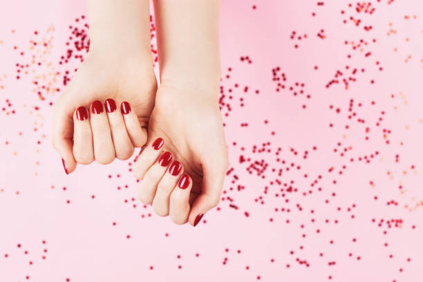 istock Two woman hands and falling confetti on pink background. 1270615840