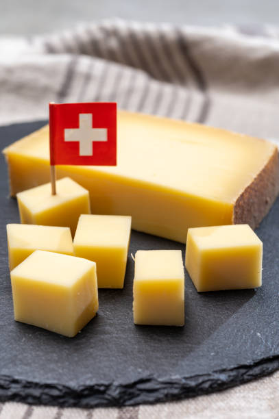блок швейцарского средне-жесткого созревенного сыра gruyere используется для выпечки, киш, фондю, бутерброды - fondue swiss culture winter cheese стоковые фото и изображения