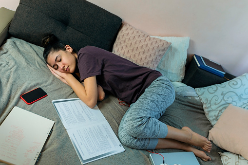 Sleepy teenage girl  at home.She is  in her bedroom.She is  fell asleep doing her homeworkCopy space