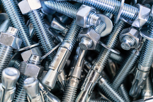 Pile of screws and nuts and bolts in a bucket in a factory