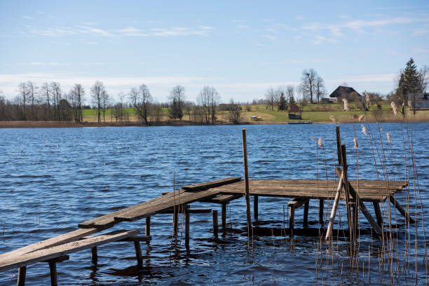 istock Small old wooden pier on still lake. Spring sunny Day. 1270617414