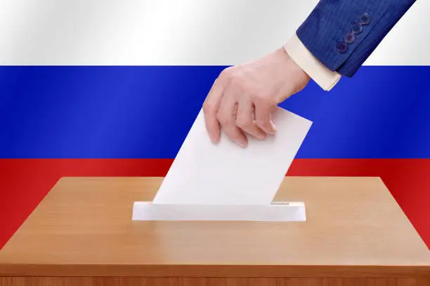Election day in the Russian Federation. A man votes by throwing a ballot into the ballot box.