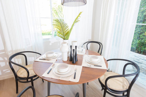 istock Modern dining room with a round table and wood chairs. 1270620555