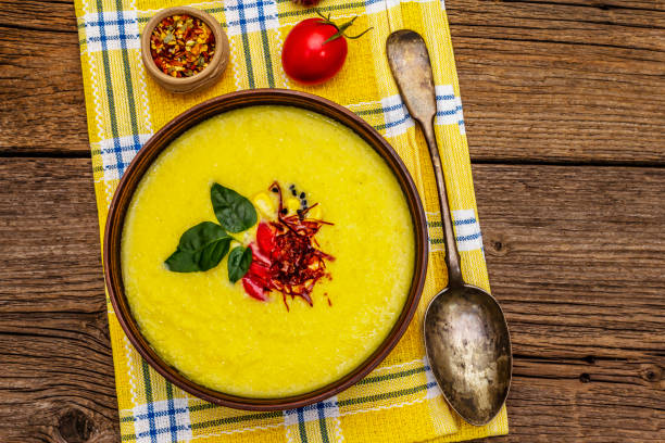 istock Corn cream soup with fresh vegetables, herbs and spices. Classic autumn hot dish, stone concrete background 1270620562