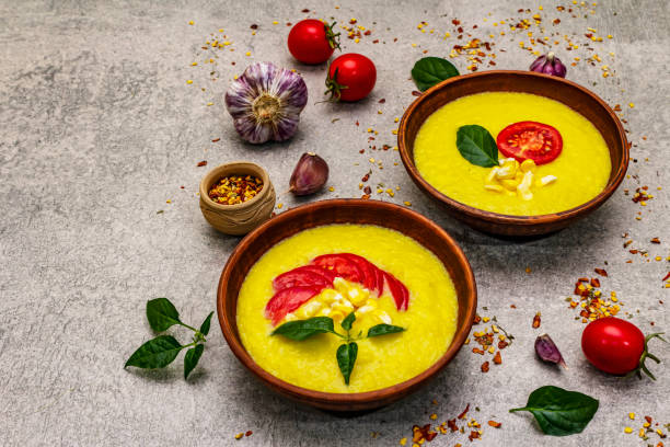 istock Corn cream soup with fresh vegetables, herbs and spices. Classic autumn hot dish, stone concrete background 1270620619