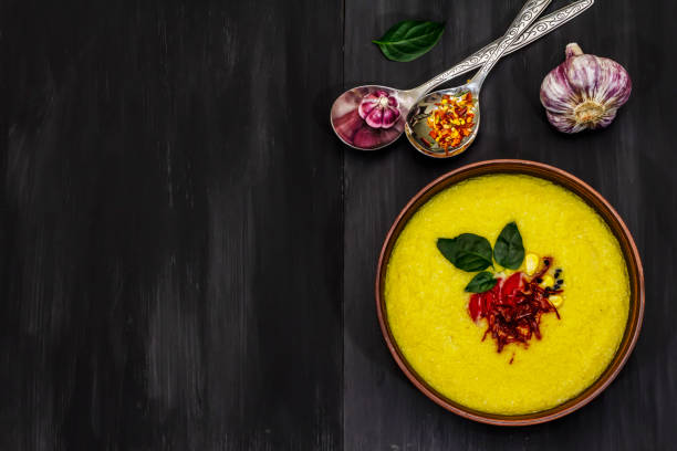 istock Corn cream soup with fresh vegetables, herbs and spices. Classic autumn hot dish, stone concrete background 1270620689