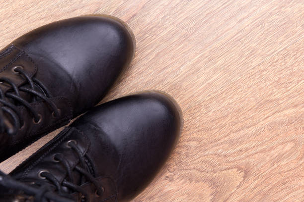istock black leather boots over wooden background 1270623030