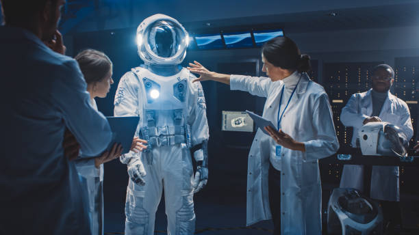 istock Diverse Team of Aerospace Scientists and Engineers Wearing White Coats have Discussion, Use Computers Design New Space Suit Adapted for Galaxy Exploration and Travel. Constructing Astronaut Suit 1270623342