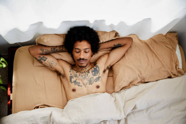 istock Young man lying asleep in his bed in the morning 1270623430