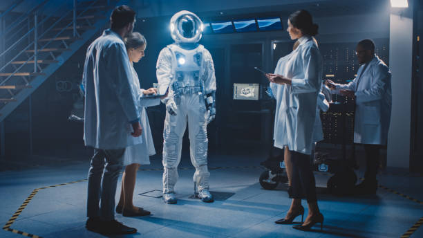 istock Diverse Team of Aerospace Engineers Design New Space Suit Adapted for Galaxy Exploration and Travel. Group of Scientists Wearing White Coats have Discussion, Use Computers. Constructing Astronaut Suit 1270623552
