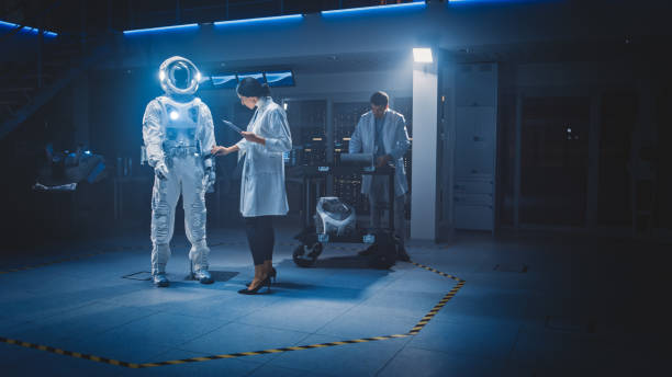istock Diverse Team of Aerospace Scientists and Engineers Wearing White Coats Use Computers to Design New Space Suit Adapted for Galaxy Exploration and Travel. Constructing Astronaut Suit 1270623559