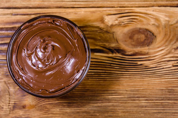 istock Glass bowl with chocolate spread on a wooden table. Top view 1270623742
