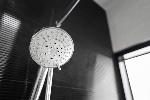 A modern luxury rain shower head in the bathroom. Close-up and selective focus at the object.
