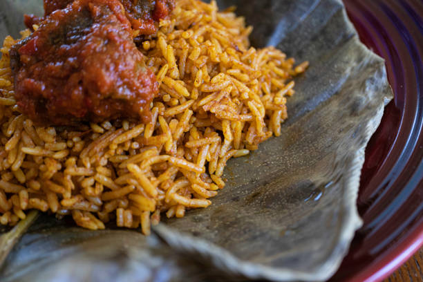 nigerianischer spicy jollof reis auf einem blatt serviert - canada rice stock-fotos und bilder