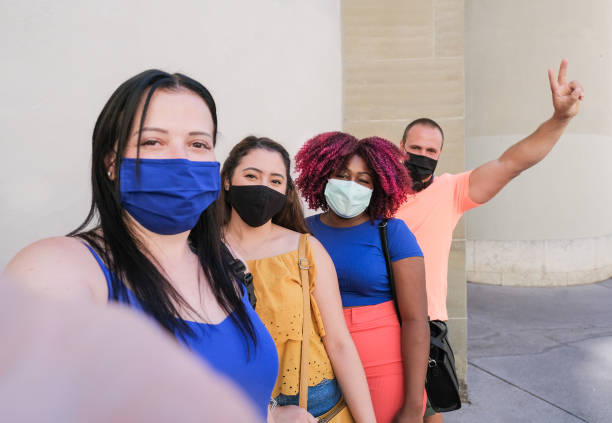 istock Cheerful multiracial friends taking a selfie while wearing protective face mask - Young people enjoy time togheter outdoor - Coronavirus lifestyle 1270628616