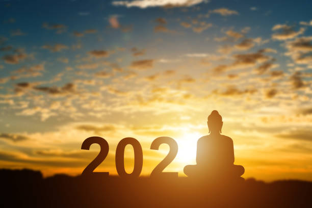 istock Silhouette of buddha with 2021 years at sunset background. 1270628864