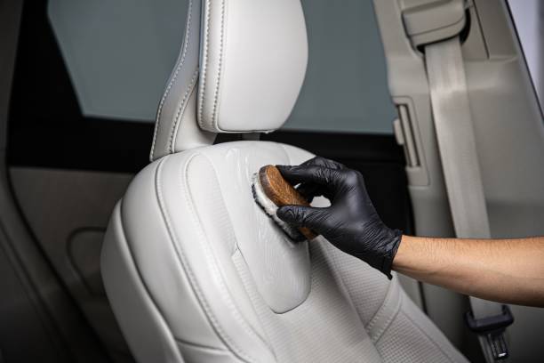 Man car detailing studio worker cleaning car leather seat with a brush. Man car detailing studio worker cleaning car leather seat with a brush. Car detailing leather care stock pictures, royalty-free photos & images