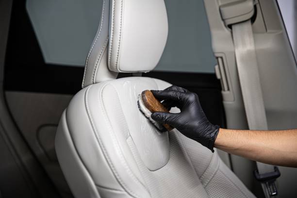 man car detailing studio worker cleaning car leather seat with a brush. - car cleaning inside of indoors imagens e fotografias de stock