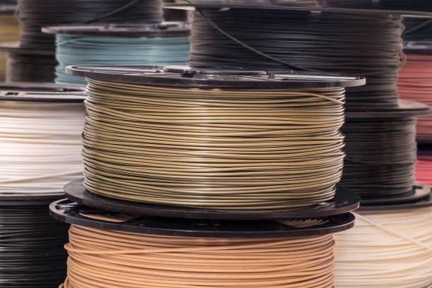 istock Spool of bronze color PLA plastic filament for 3D printer. 1270632812