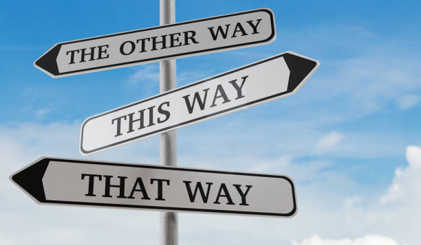istock Confusing road sign arrows pointing in different directions. Decision and choice concept. 3D rendered illustration. 1270632909