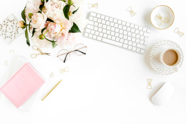 istock Flat lay women's office desk. Female workspace with computer, pink peonies bouquet, accessories on white background. Top view feminine background 1270633245
